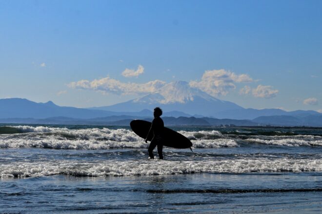 Surfer in Enoshima mit Fuji im Hintergrund