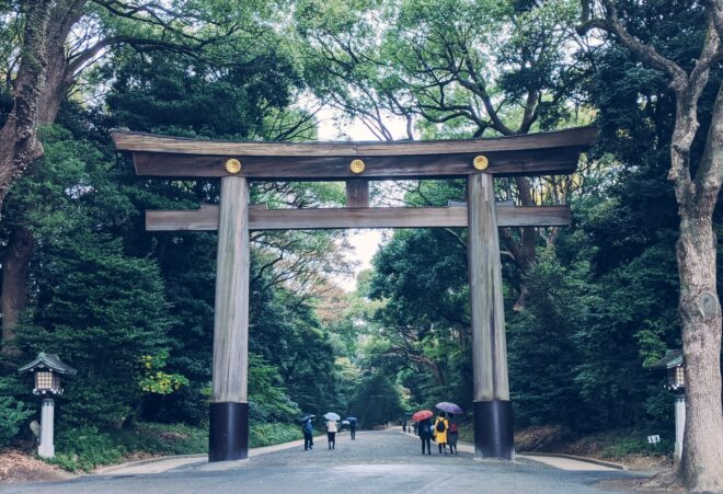Ein hölzernes torii markiert den Eingang zum Meiji Jingu in Tokyo