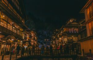 Abseits der ausgetretenen Pfade - Teil 6: Yamagata 1 Ginzan Onsen in Yamagata (Foto von: <a href="https://unsplash.com/@hktram0311?utm_content=creditCopyText&utm_medium=referral&utm_source=unsplash">HANVIN CHEONG</a> on <a href="https://unsplash.com/photos/a-city-street-at-night-with-people-walking-on-the-sidewalk-mXsL2M5fsL8?utm_content=creditCopyText&utm_medium=referral&utm_source=unsplash">Unsplash</a>)